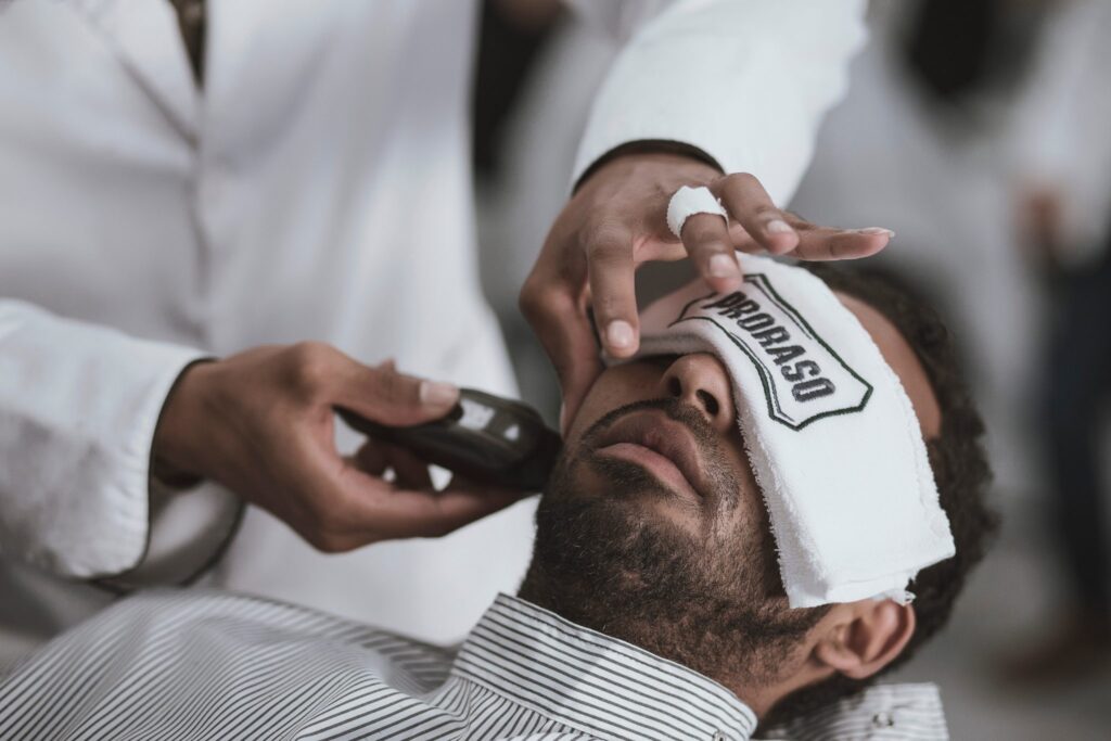how to look younger - photo of man at barber getting shave