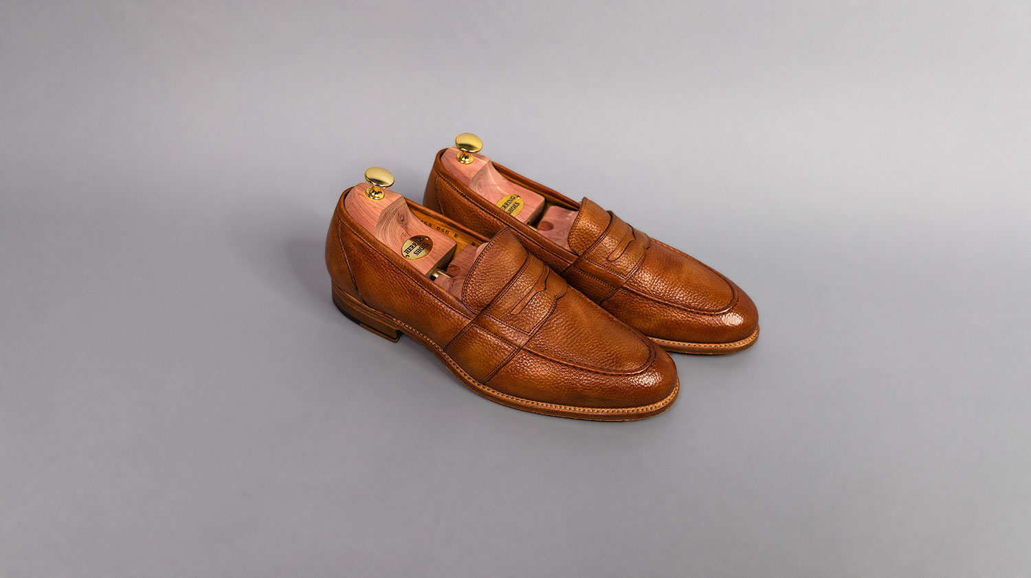tan leather loafers from Herring on gray background