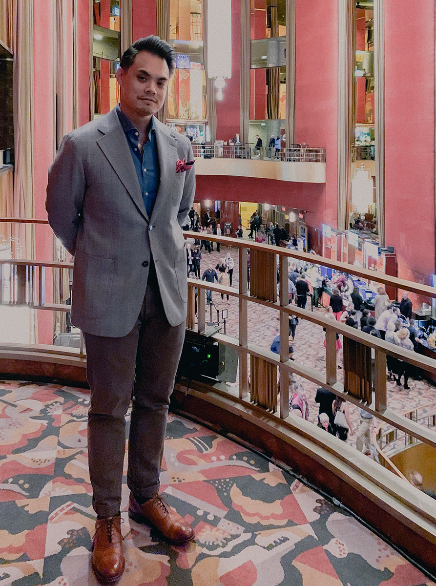man standing next to railing inside a theater