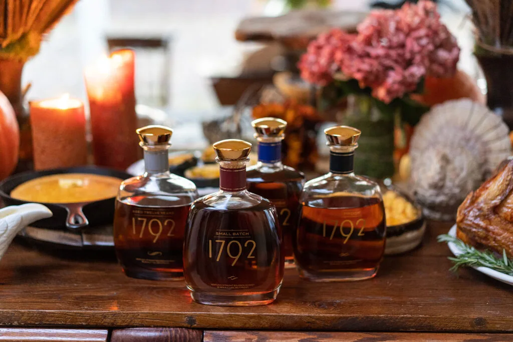 four bottles of bourbon on a Thanksgiving table setting - credit 1792 style