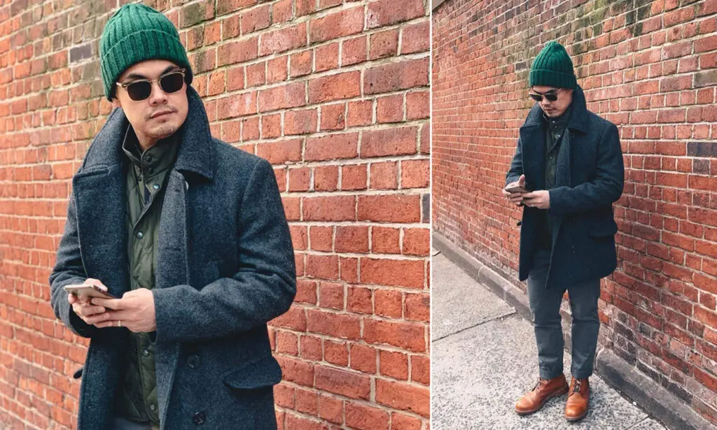 man wearing grey peacoat and green beanie and tan boots