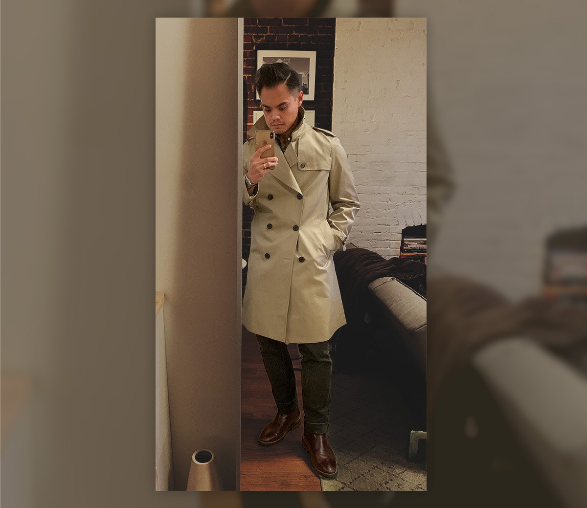 man taking photo in mirror wearing a tan trench coat
